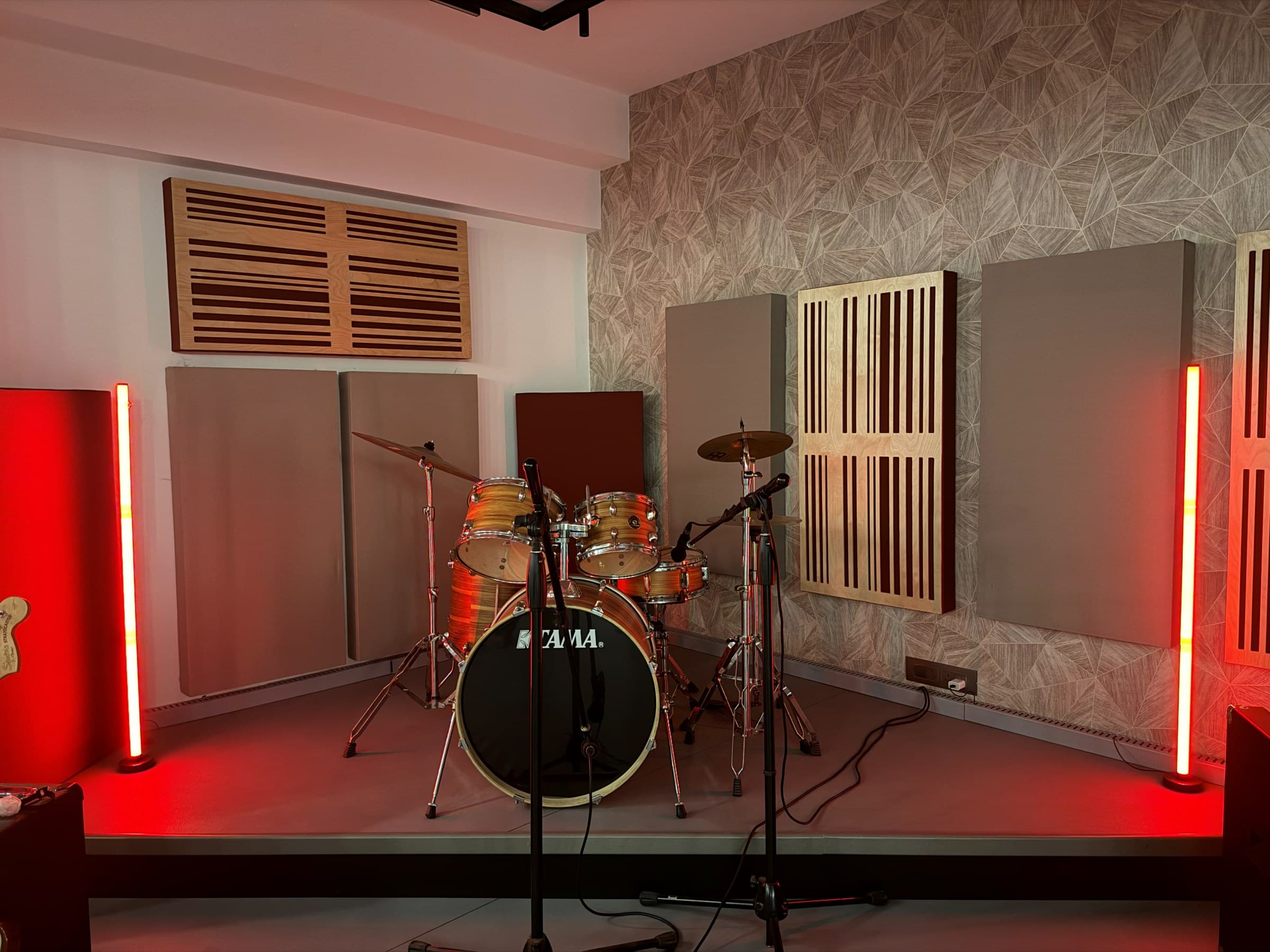Live room stage with drum kit framed by red light bars