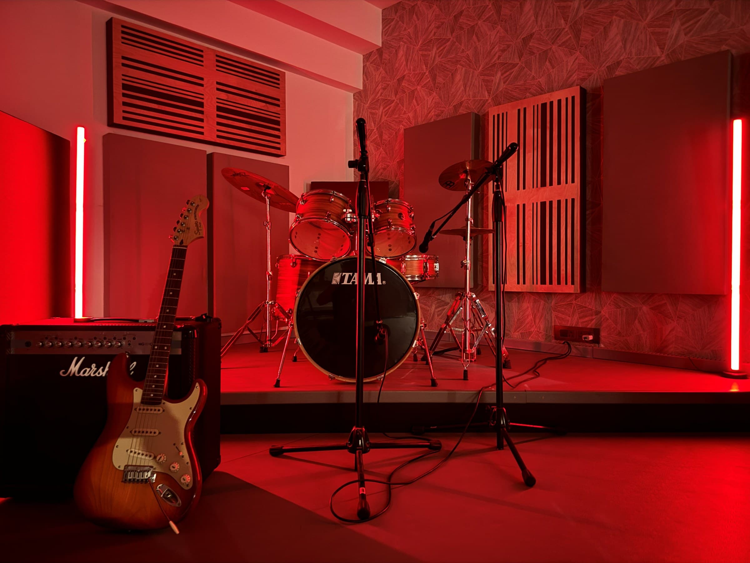 Kings Club Studio live room bathed in red light with drum kit and guitar